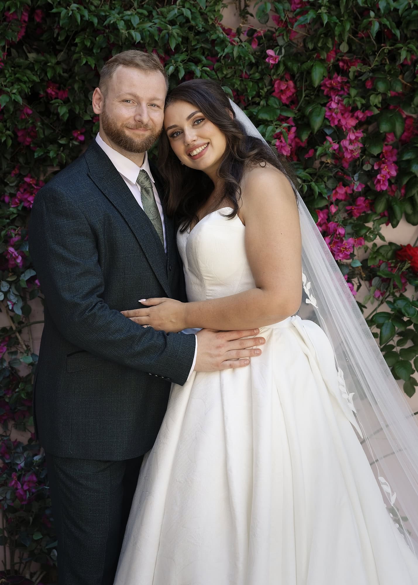 Couple portrait against the courtyard's flowering wall at Port Lympne