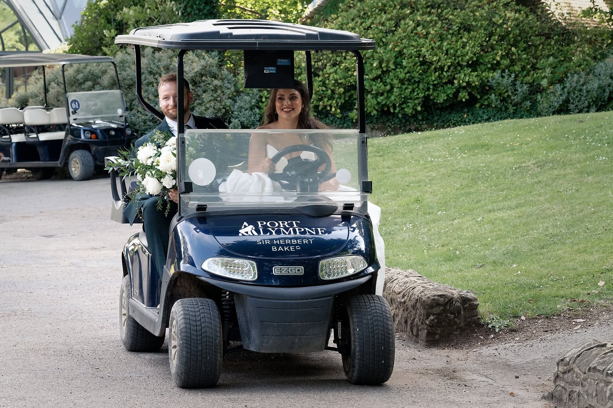 Jade driving the golf buggy back to the hotel, Josh riding alongside with her bouquet