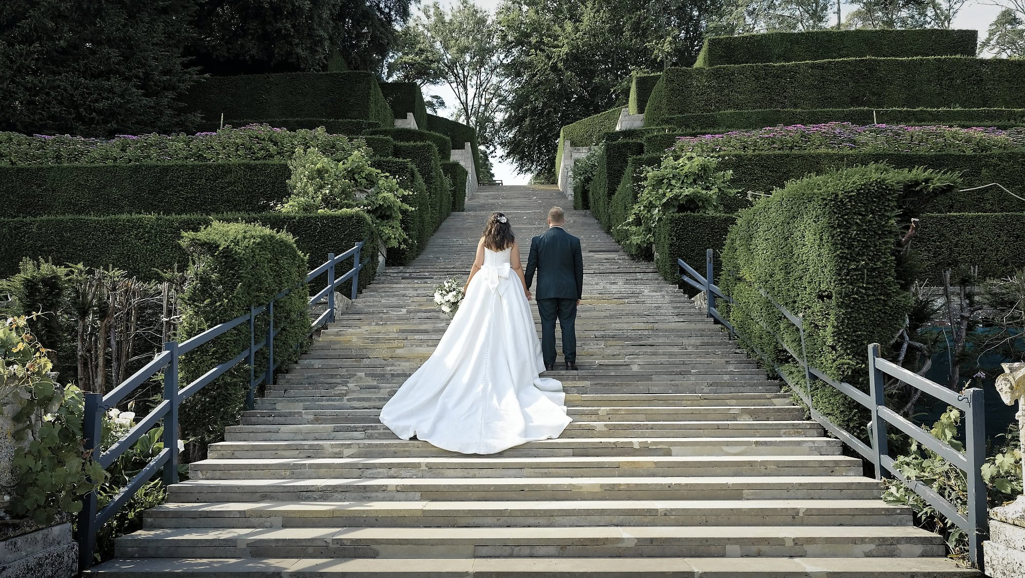 Bride and groom viewed from behind, walking up the grand steps