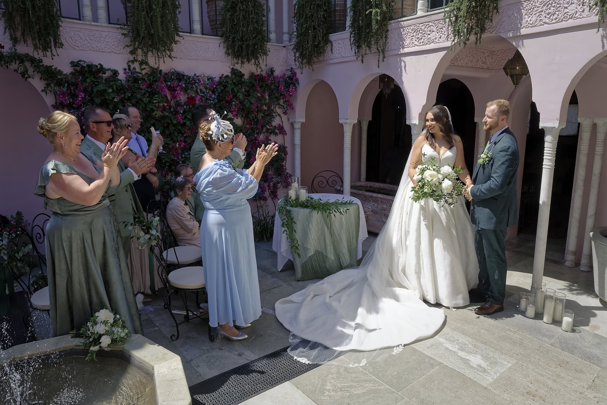 Guests applauding as Jade and Josh come together after their ceremony in the Moroccan Courtyard