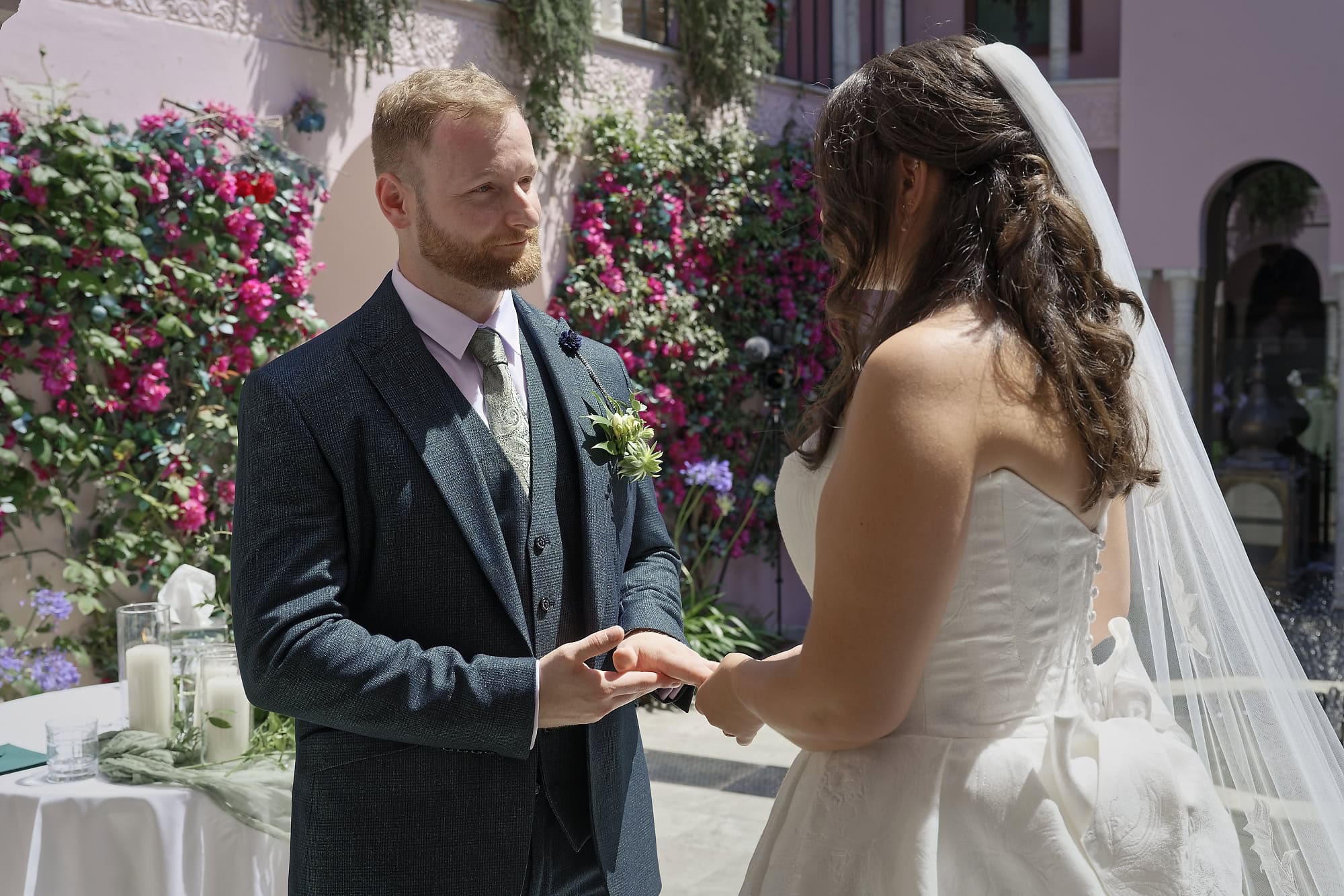 A close moment between bride and groom as rings are exchanged at the altar in the Moroccan Courtyard
