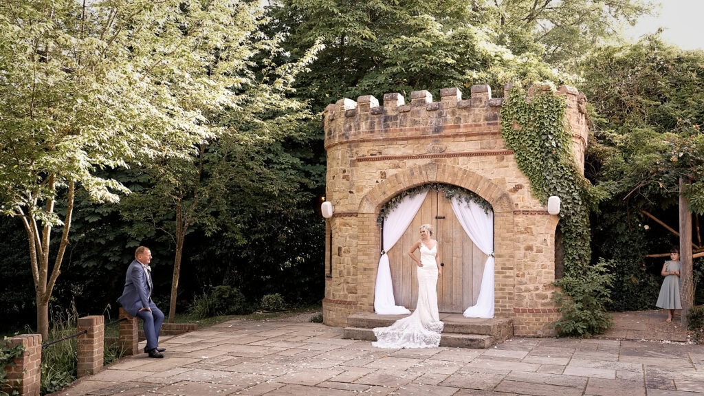 Bride in front of little castle at the Ravenswood smiling at her groom in a quite moment in the evening light
