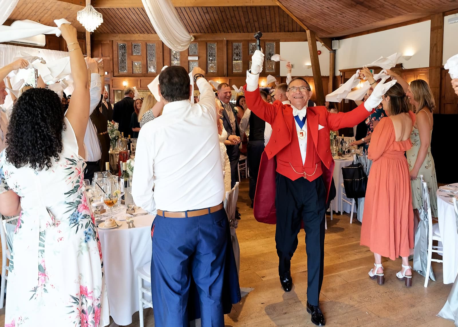 Toastmaster leading the couple's grand entrance as guests wave napkins at The Ravenswood