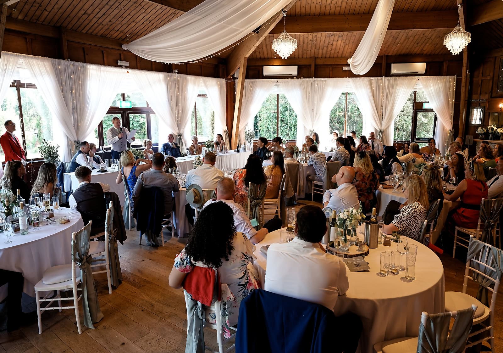 Wedding breakfast room with draped ceiling and chandeliers at The Ravenswood
