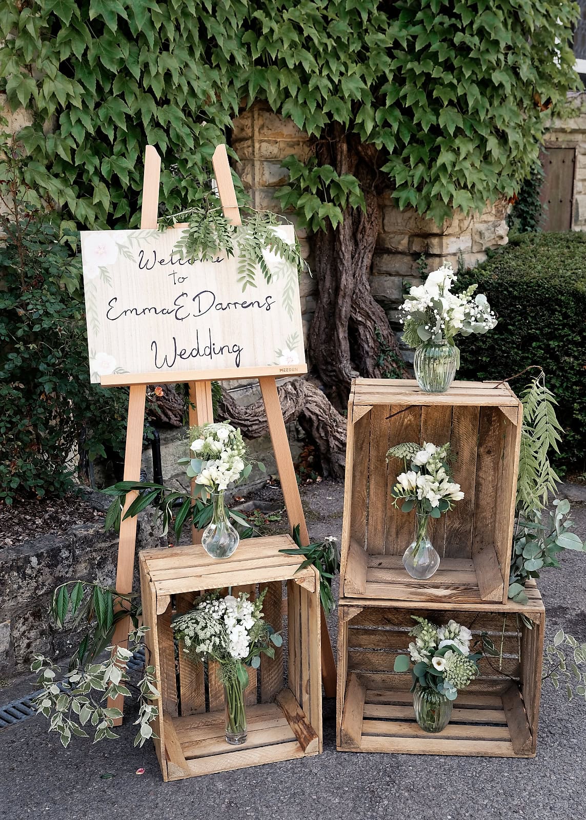 Hand-painted sage green welcome sign and white florals at The Ravenswood