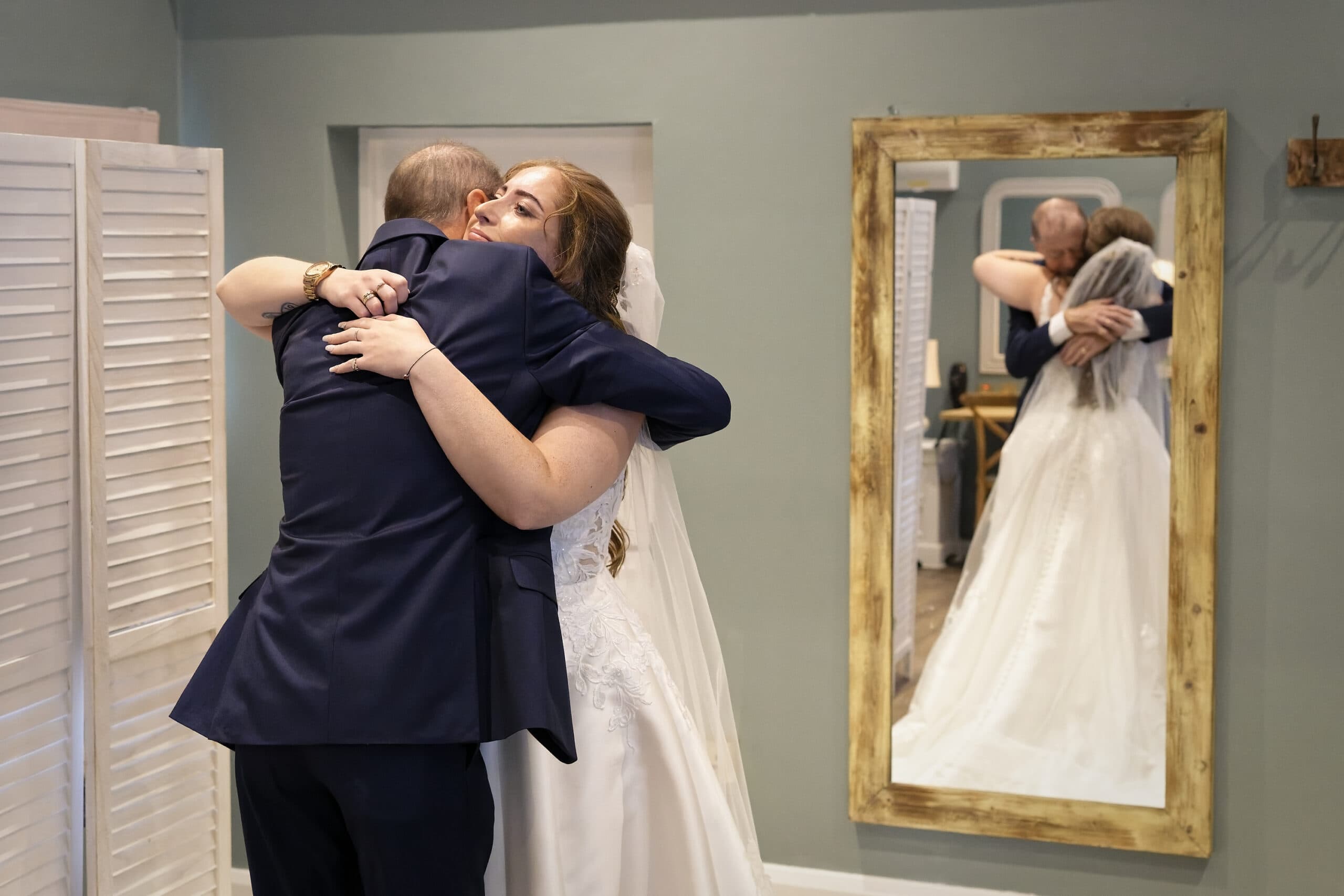 Bride hugging her dad tight during their first look before the ceremony, reflected in a mirror at the Cottesmore Hotel