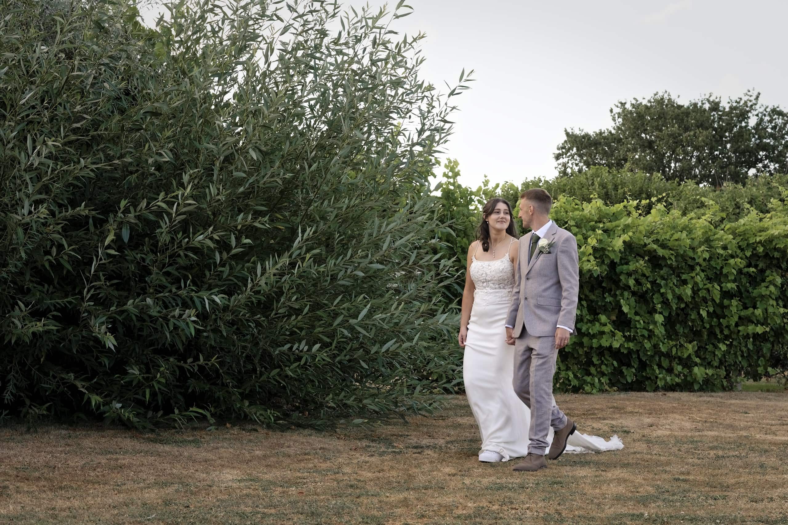Couple strolling hand in hand through the gardens at Grittenham Barn