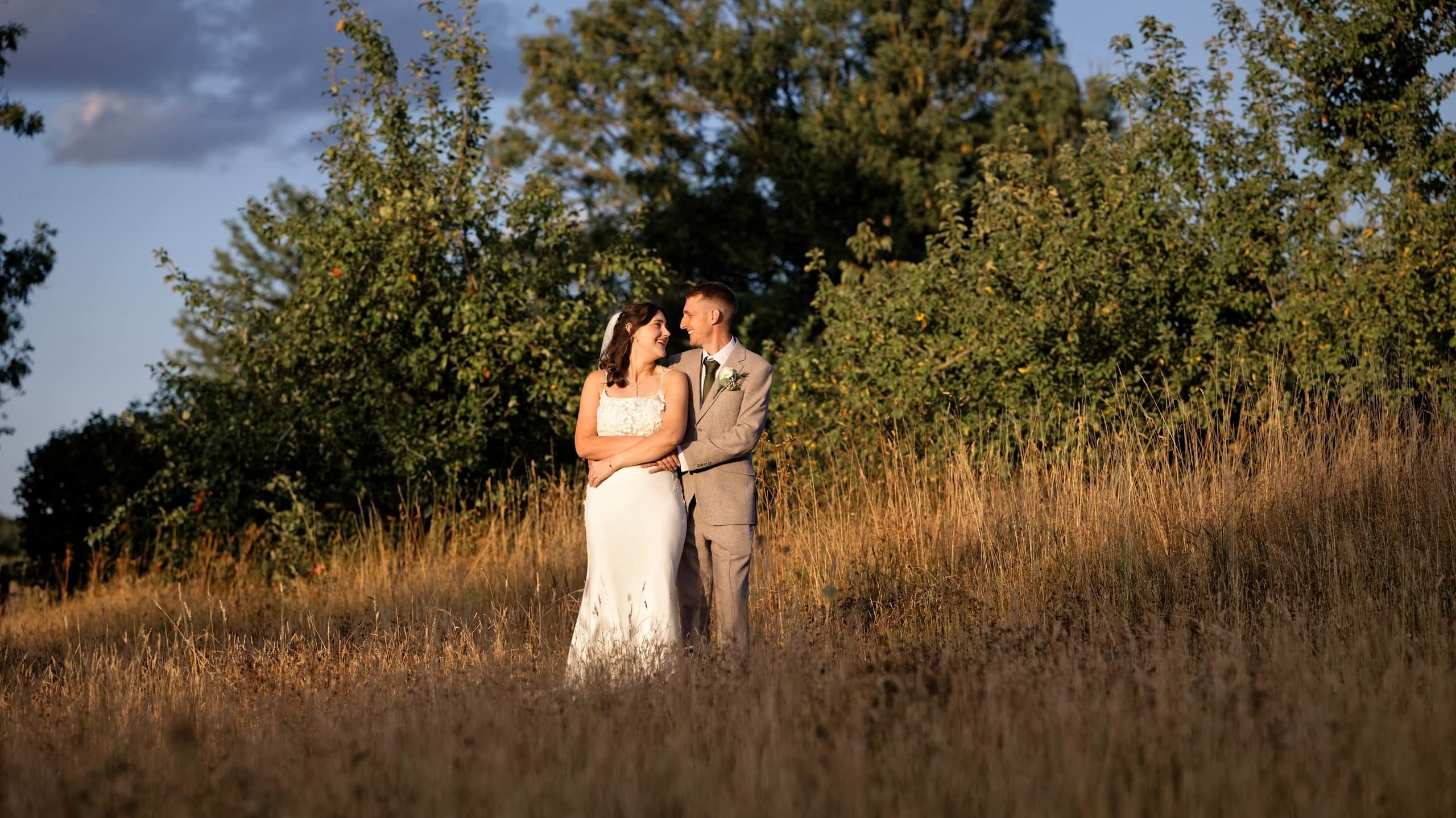 Golden hour couple portrait in the meadow, captured by a Grittenham Barn wedding photographer