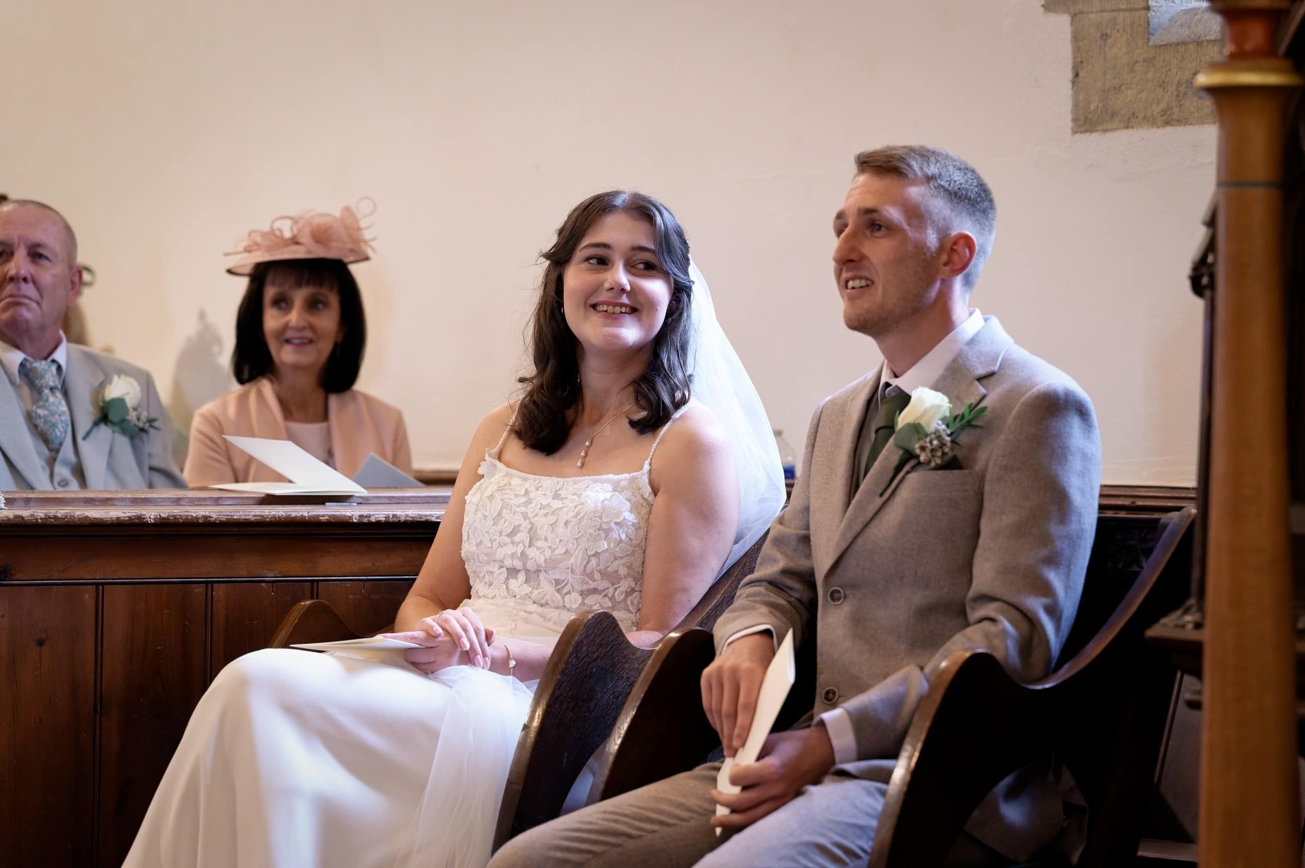 Bride and groom laughing together during their church wedding ceremony in West Sussex