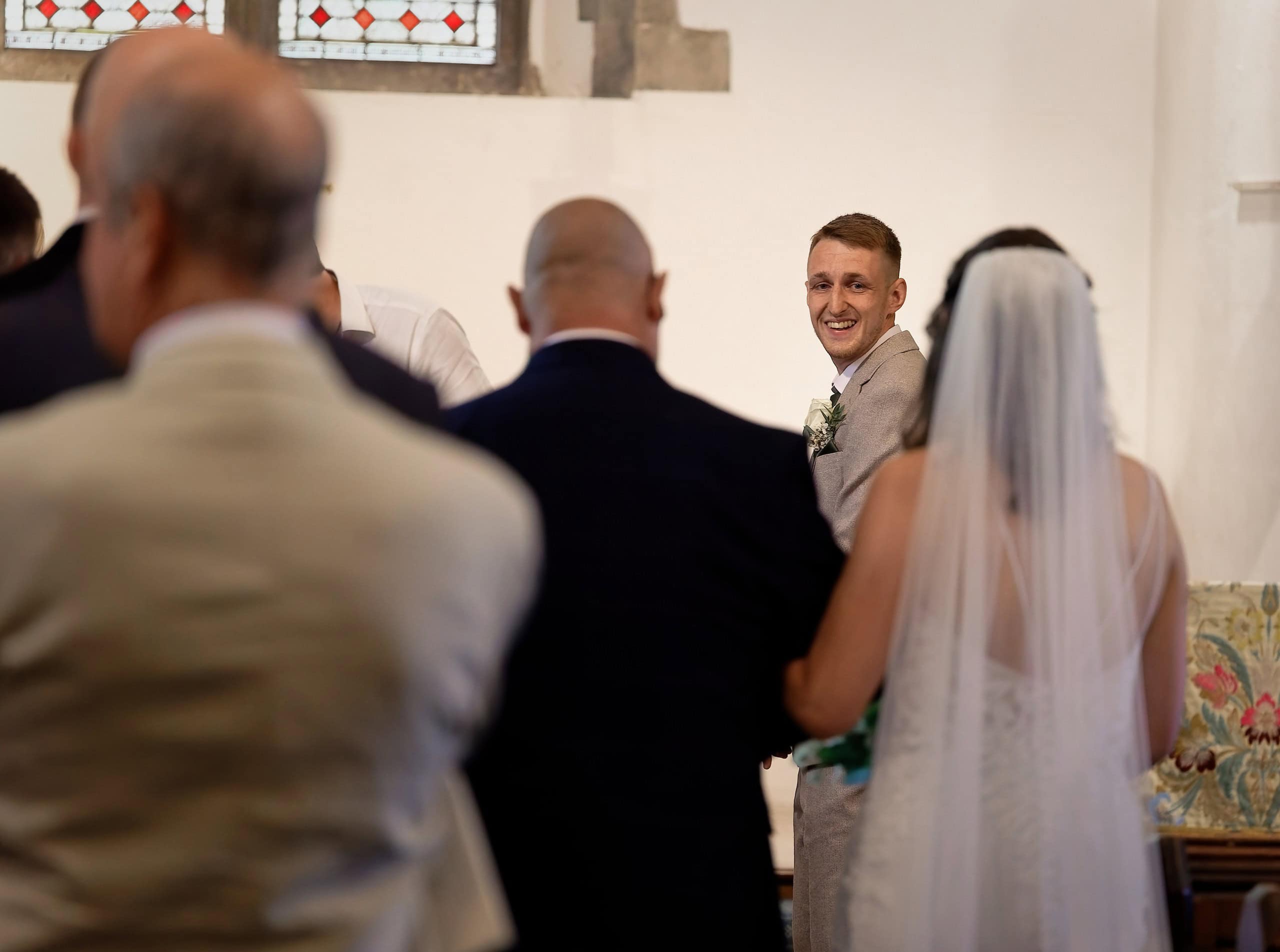 Groom beaming as his bride reaches the front of the church